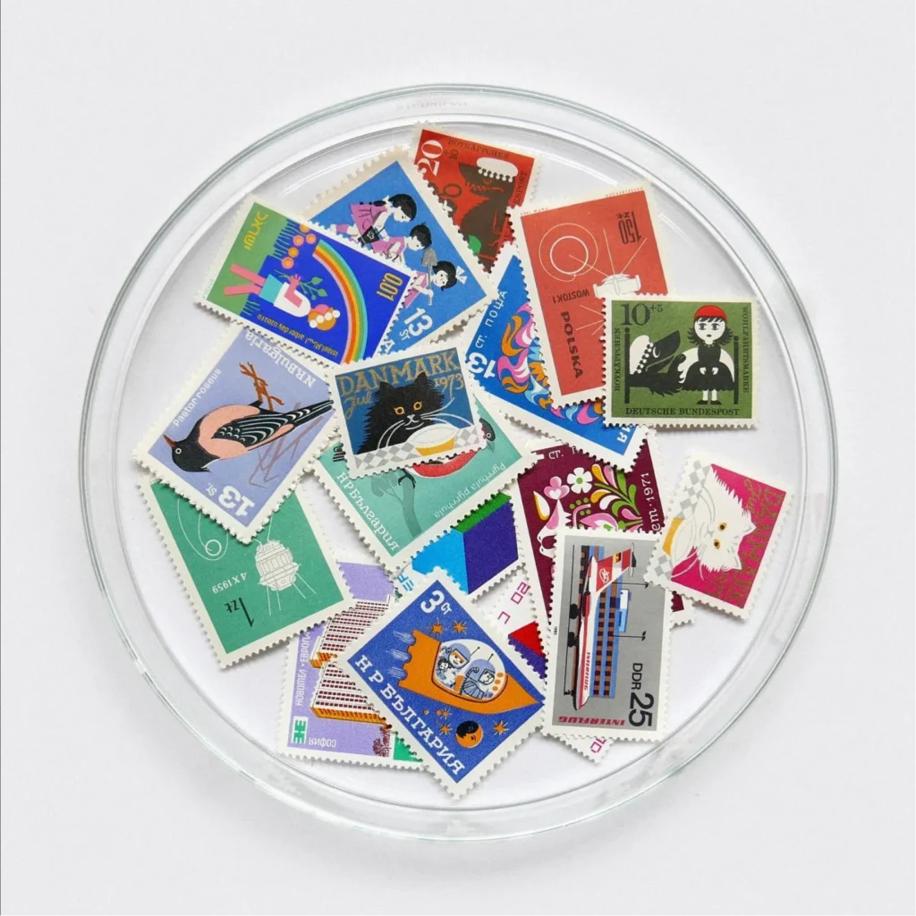 Colorful stamps arrayed in a clear glass dish