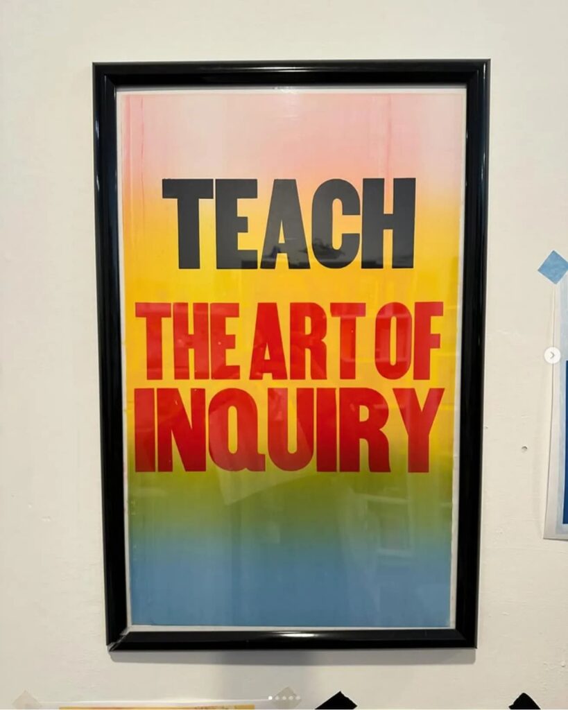 A poster that reads "teach the art of inquiry" in black and red letters